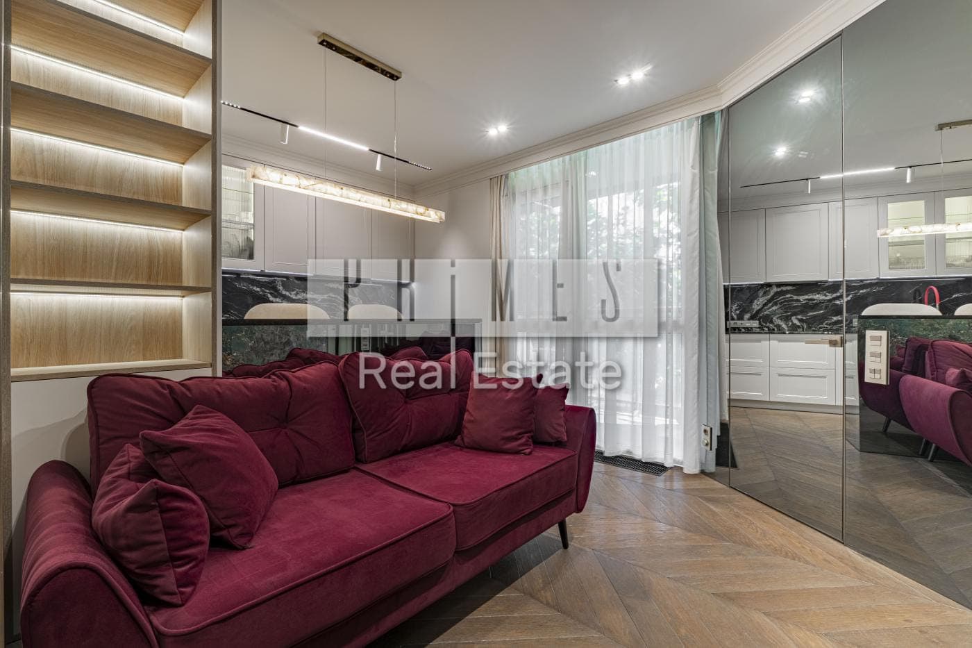 Kitchen-living room with a raspberry velvet sofa and lit shelving — Frantsuzkyi Kvartal 2